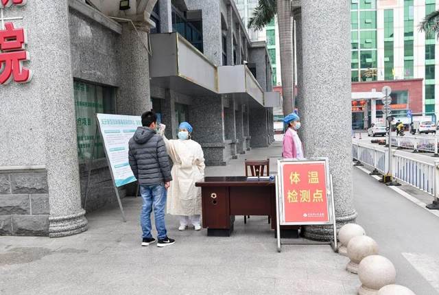 图为护士在医院大门体温监测点测体温.jpg