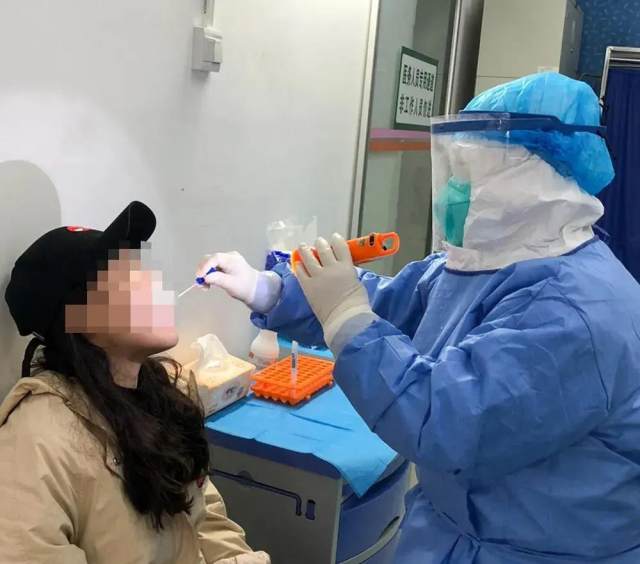 图为岑瑜为发热病人采集咽拭子.jpg